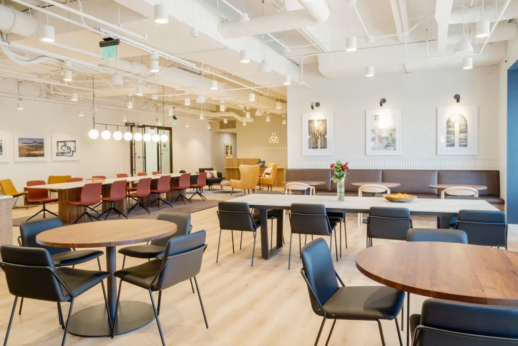 The central coworking area with many tables and chairs at Industrious office coworking space, 301 Congress in Austin.